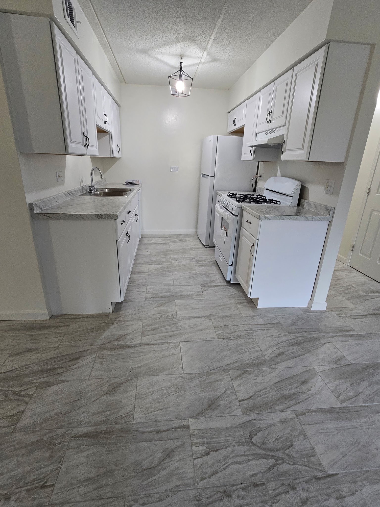 A kitchen with white appliances and cabinets.